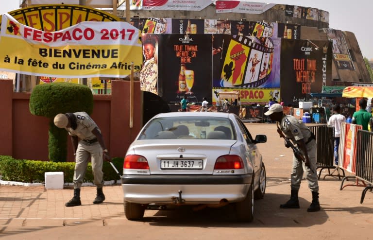 Police officers check cars at the entrance to the Pan-African Film and Television Festival (FESPACO) in Ouagadougou