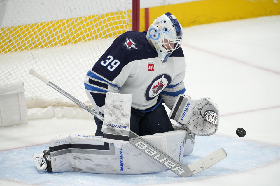 Winnipeg Jets goaltender Laurent Brossoit reaches out to glove a shot from the Dallas Stars during the first period of an NHL hockey game in Dallas, Thursday, April 11, 2024. (AP Photo/Tony Gutierrez)