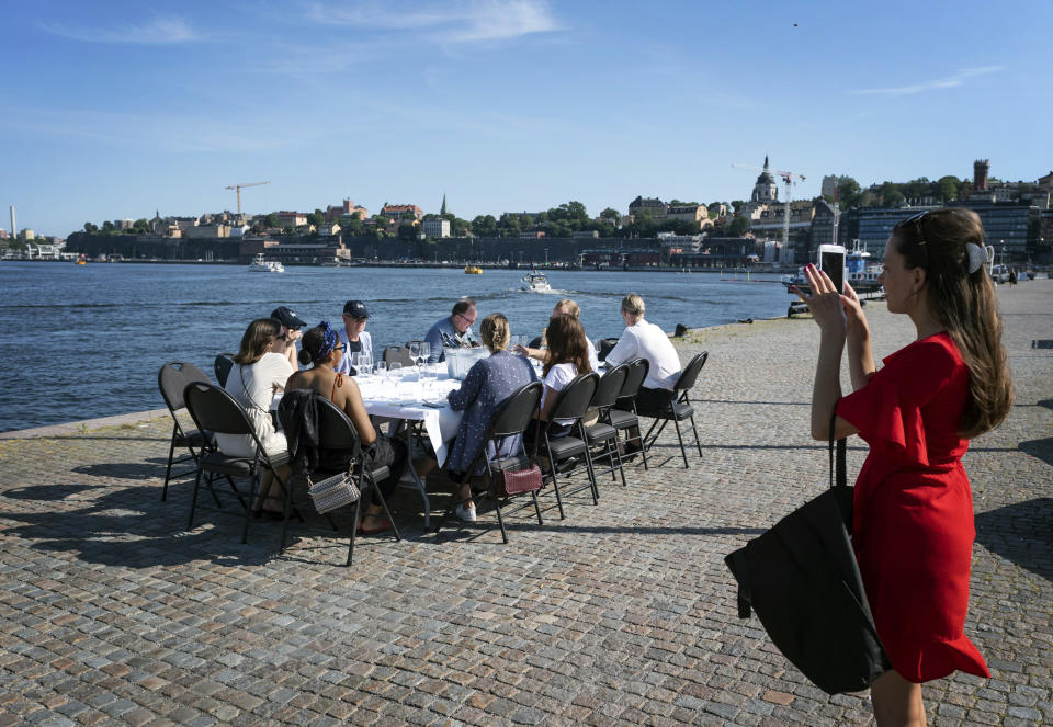 ARCHIVO - En esta imagen de archivo del viernes 26 de junio de 2020, empleados guardando la distancia social para beber algo tras trabajar, en Estocolmo. (Stina Stjernkvist/TT News Agency via AP, Archivo)