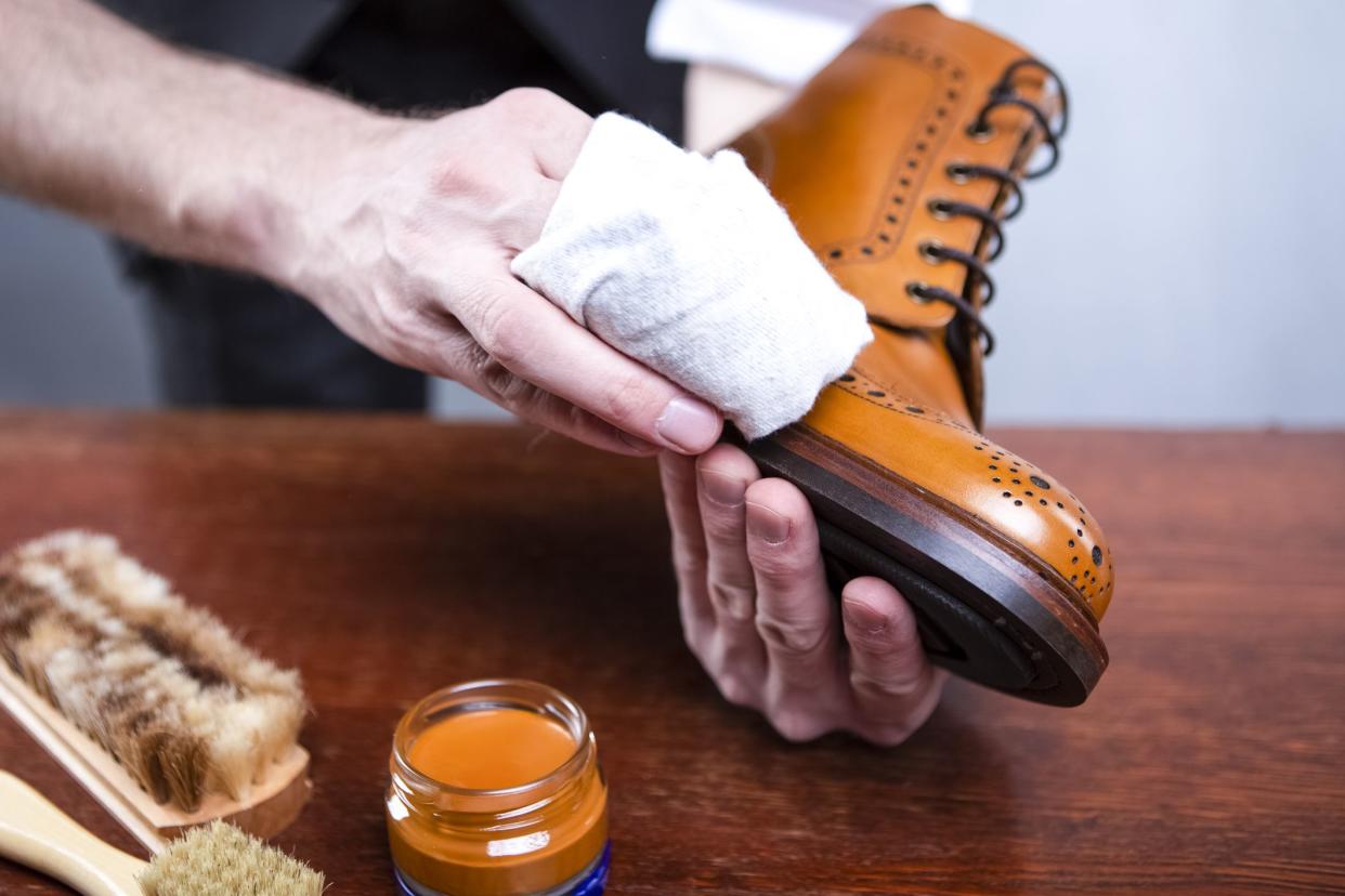 Close Up of Mans Hands Cleaning Luxury Calf Leather Brogues with Special Cloth. Horizontal image Orientation