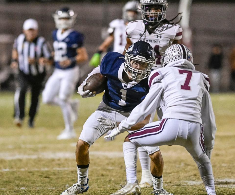 Redwood's Evan Galley tries to evade Mt. Whitney's Noah Murillo in the 68th annual rivalry Cowhide game Friday, October 27, 2023.