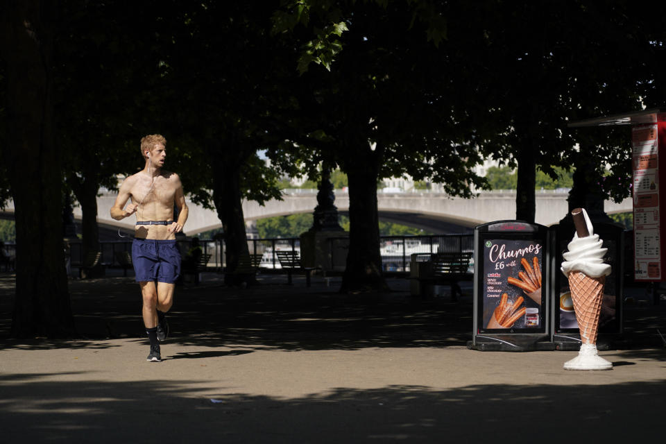 A man runs past an ice-cream sign, on the south bank of river Thames, in London, Monday, July 18, 2022. Britain’s first-ever extreme heat warning is in effect for large parts of England as hot, dry weather that has scorched mainland Europe for the past week moves north, disrupting travel, health care and schools. (AP Photo/Alberto Pezzali)
