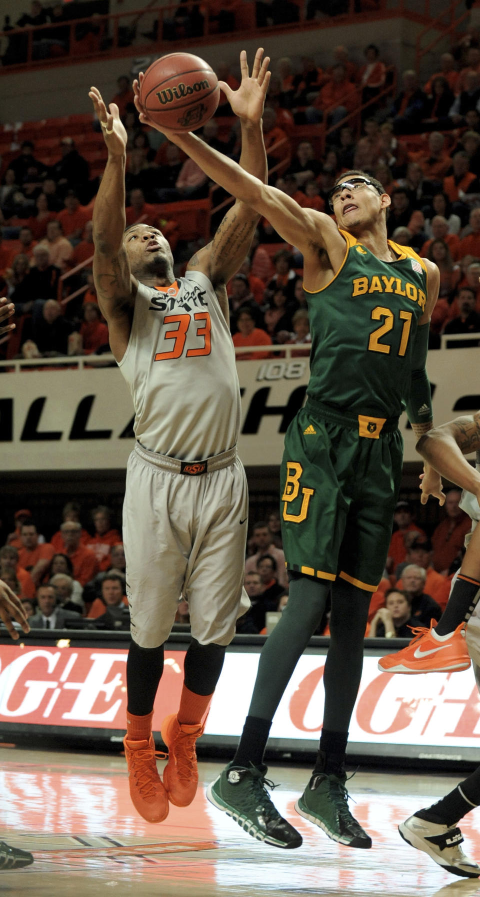 Baylor center Isaiah Austin (21) and Oklahoma State guard Marcus Smart reach for a rebound during the first half of an NCAA college basketball game in Stillwater, Okla., Saturday, Feb. 1, 2014. (AP Photo/Brody Schmidt)