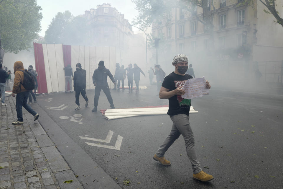 Youths set up a barricade during a banned protest in support of Palestinians in the Gaza Strip, in Paris, Saturday, May, 15, 2021. Marches in support of Palestinians in the Gaza Strip were being held Saturday in a dozen French cities, but the focus was on Paris, where riot police got ready as organizers said they would defy a ban on the protest. (AP Photo/Rafael Yaghbozadeh)