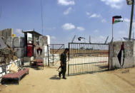 FILE -A Palestinian security officer loyal to Hamas opens a gate to the Philadelphi corridor between Egypt and Gaza near the southern Gaza Strip town of Rafah, July, 1, 2007. (AP Photo/Khalil Hamra, File)