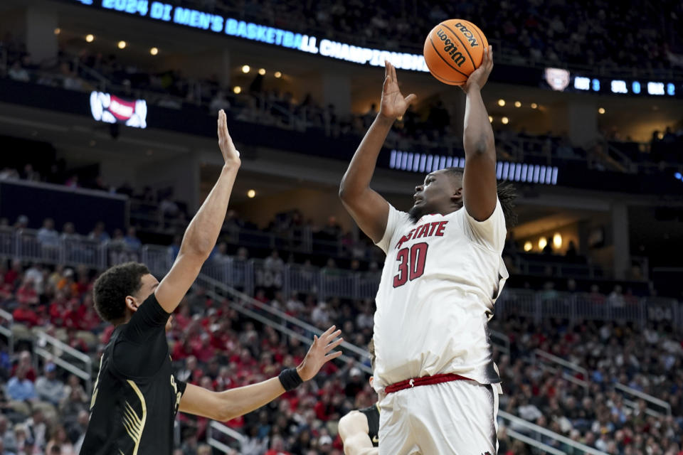 North Carolina State's DJ Burns, Jr. (30) shoots over Oakland's Chris Conway during the first half of a second-round college basketball game in the NCAA Tournament Saturday, March 23, 2024, in Pittsburgh. (AP Photo/Matt Freed)