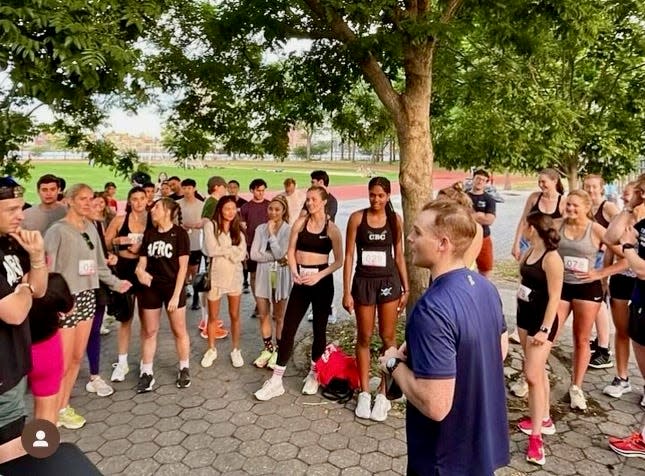 Sam Norton presents instructions at an Almost Friday Running Club track event in June to participants, who were to chug a beer before each quarter mile. He won the event in 2022 and 2023.