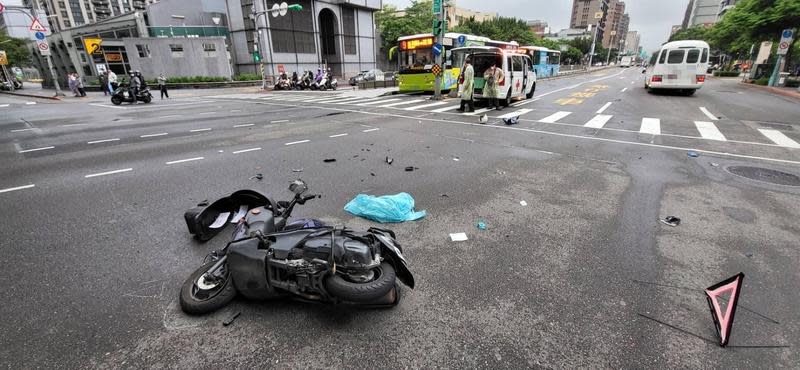 機車騎士在路口攔腰撞上救護車，造成機車解體零件四散。（翻攝畫面）