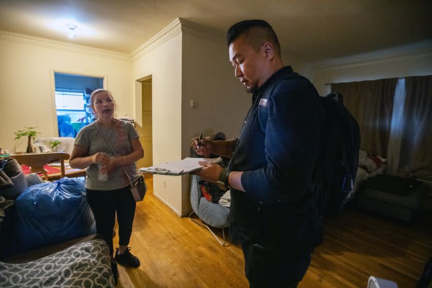 A woman speaks with a therapist about her son in her apartment in Los Angeles.