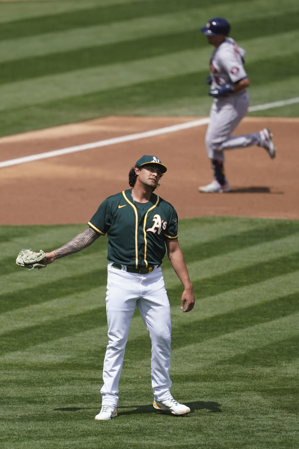 Houston Astros' Jason Castro, top, rounds the bases after hitting a two-run home run off Oakland Athletics pitcher Sean Manaea, bottom, during the second inning of a baseball game in Oakland, Calif., Sunday, April 4, 2021. (AP Photo/Jeff Chiu)