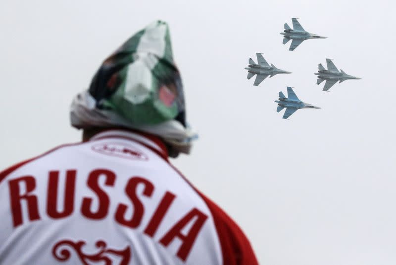 FILE PHOTO: A spectator watches Sukhoi Su-30SM jet fighters of the Sokoly Rossii aerobatic team perform during the MAKS International Aviation and Space Salon in Zhukovsk