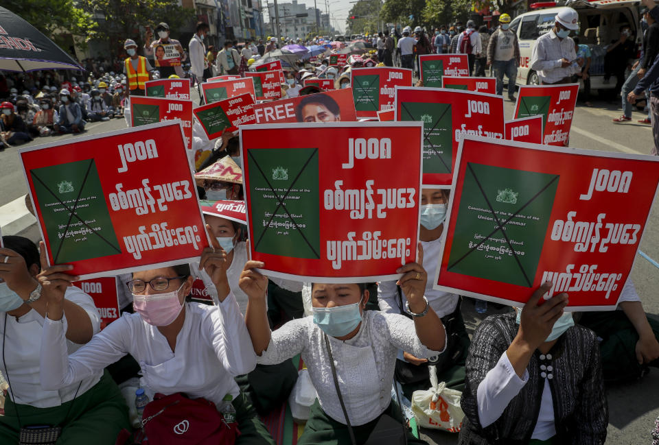 Anti-coup protesters stage a sit-in protest in Mandalay, Myanmar, Wednesday, Feb. 24, 2021. Protesters against the military's seizure of power in Myanmar were back on the streets of cities and towns on Wednesday, days after a general strike shuttered shops and brought huge numbers out to demonstrate. Placards reads as "Abolish 2008 Military Slave Law." (AP Photo)