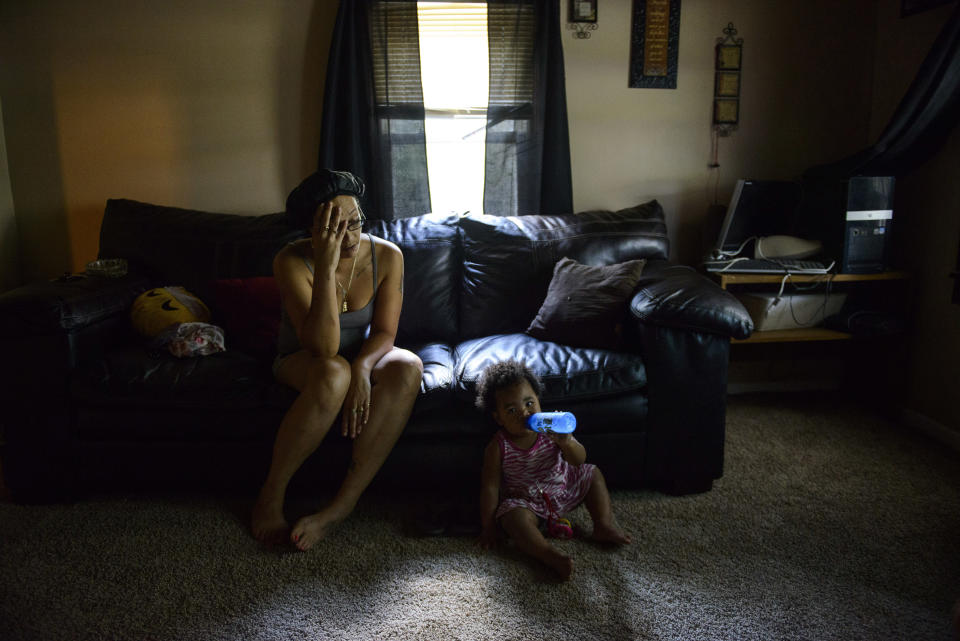 RETRANSMISSION TO CORRECT LOCATION TO LUMBERTON - Priscilla Godwin talks about the last week dealing with effects of Hurricane Florence, while her daughter Kanaiya McCormick, 1, sits by her side, Thursday, Sept. 20, 2018, in Lumberton, N.C. Godwin, 32, was born and raised in the house that used to belong to her mother. She now lives in the house with her two children and boyfriend Craig. "This is all we have, so we have to make it right," said Godwin. A friend provided a square of carpet for the living room so the kids had a place to sit. With school and day cares closed, Godwin has struggled to get work done while watching her two children as well. (Melissa Sue Gerrits/The Fayetteville Observer via AP)