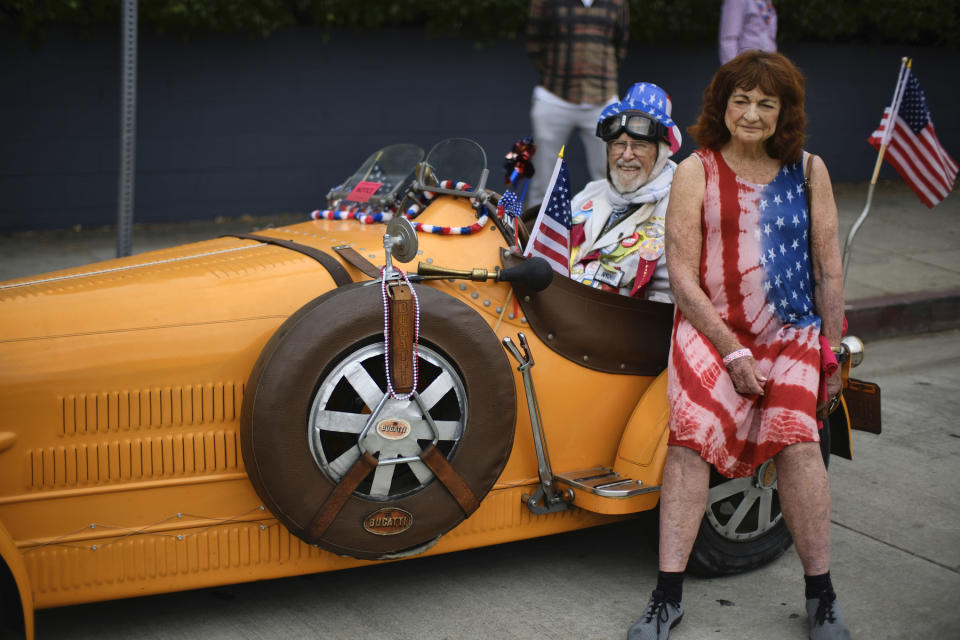 Karen Miller rests with Dr. Bernard Harris on his Bugatti classic car during the Santa Monica Fourth Of July Parade on Thursday, July 4, 2019 in Santa Monica, Calif. (AP Photo/Richard Vogel)