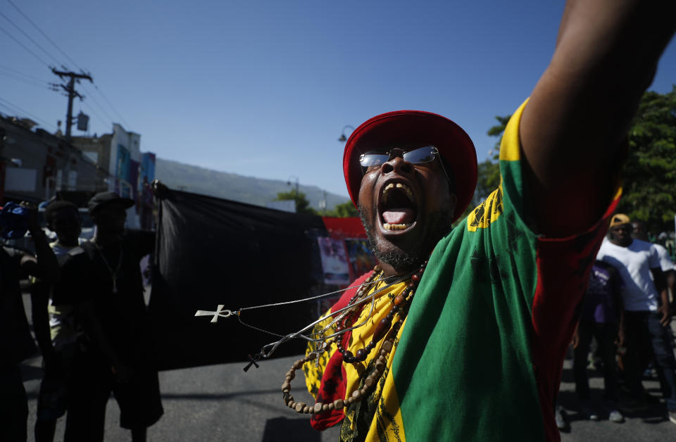 Pastor Past, of the performance group Kominote Zan77, screams during a march led by the art community that continues demanding the resignation of Haitian President Jovenel Moise in Port-au-Prince, Haiti, Sunday, Oct. 13, 2019. Protests have paralyzed the country for nearly a month, shuttering businesses and schools. (AP Photo/Rebecca Blackwell)