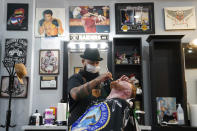 Braunson McDonald has his beard trimmed by Luis Lopez, owner of Orange County Barbers Parlor, Wednesday, July 15, 2020, in Huntington Beach, Calif. Gov. Gavin Newsom this week ordered that indoor businesses like salons, barber shops, restaurants, movie theaters, museums and others close due to the spread of COVID-19. (AP Photo/Ashley Landis)