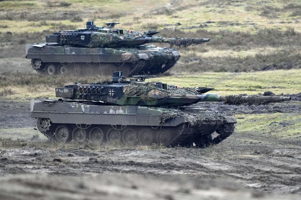 FILE - Two Leopard 2 tanks are seen in action during a visit of German Defense Minister Boris Pistorius at the Field Marshal Rommel Barracks in Augustdorf, Germany, on Feb. 1, 2023. To back future Ukrainian counterattacks, its Western allies have promised new supplies of weapons, including hundreds of tanks and other armored vehicles along with artillery, rockets and other equipment. (AP Photo/Martin Meissner, File)