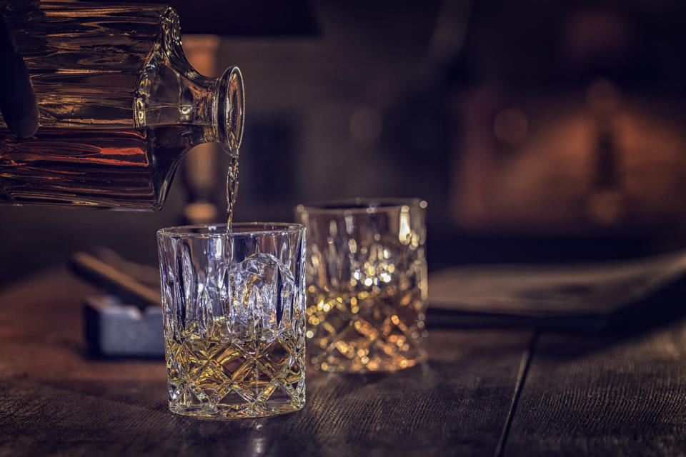 Pouring whiskey into a glass with ice