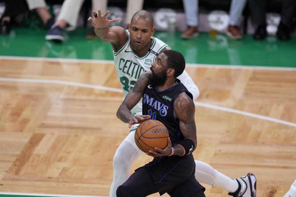 Dallas Mavericks guard Kyrie Irving drives toward the basket as Boston Celtics center Al Horford (42) defends during the first half of Game 1 of basketball's NBA Finals on Thursday, June 6, 2024, in Boston. (AP Photo/Charles Krupa)