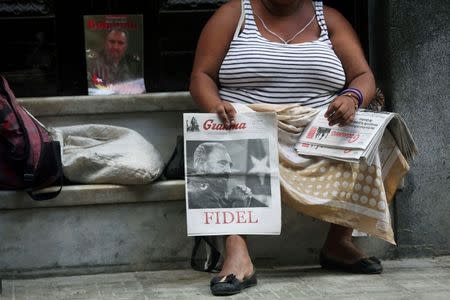 A woman sells Cuban Communist Party (PCC) official newspaper Granma with a picture of former Cuba's President Fidel Castro at the front page, at the main touristic road in Havana, Cuba, September 14, 2016. REUTERS/Alexandre Meneghini