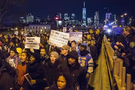 The Lower Manhattan skyline, including One World Trade Center, is seen in the background as protesters, demanding justice for Eric Garner, enter Brooklyn off the Brooklyn Bridge in New York December 4, 2014. REUTERS/Elizabeth Shafiroff