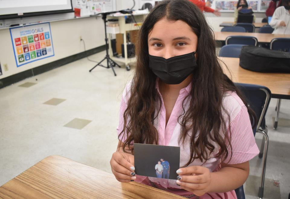 North Salinas High School student Ximena Vega holds a photo of her parents as she tells the story of their journey from Mexico to the United States.