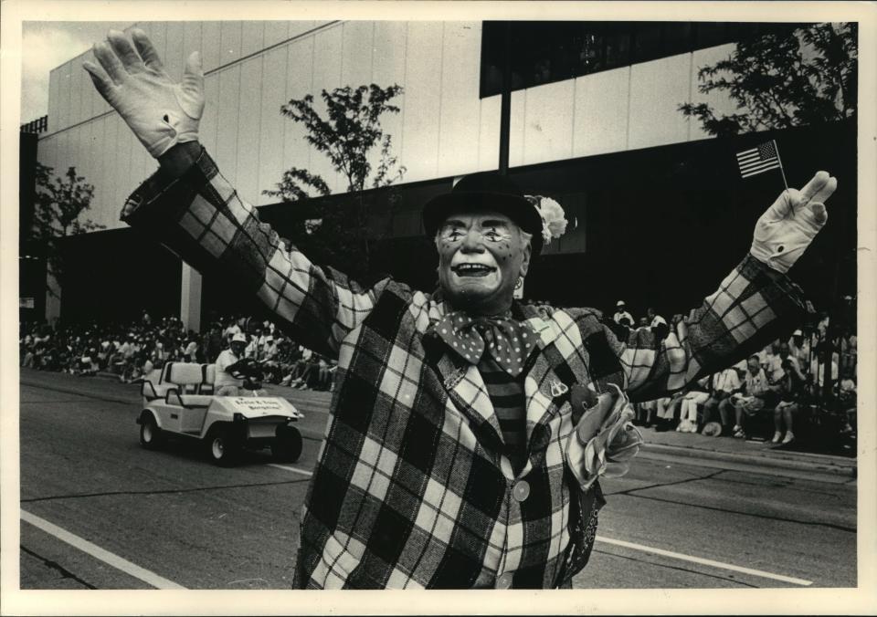 Actor Ernest Borgnine (above) carried a tiny American flag and waved to the crowd on W. Kilbourn Ave. as the 1987 Great Circus parade rolled through Downtown.  A horse-drawn wagon (right) seemed to be surrounded by spectacles as it prepared to turn south on N. 6th St.  Clown (below) tipped his hat to some of thousands along the parade route.