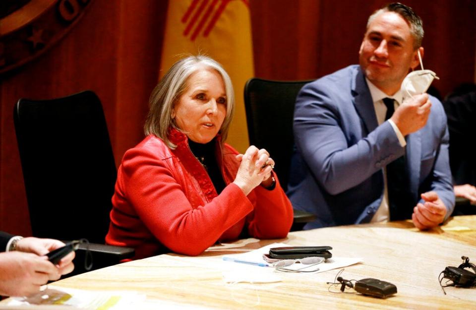 Gov. Michelle Lujan Grisham announces the end to her state's indoor mask mandate while Lt. Gov. Howie Morales, right, removes his mask on Thursday, Feb. 17, 2022, in Santa Fe, N.M.