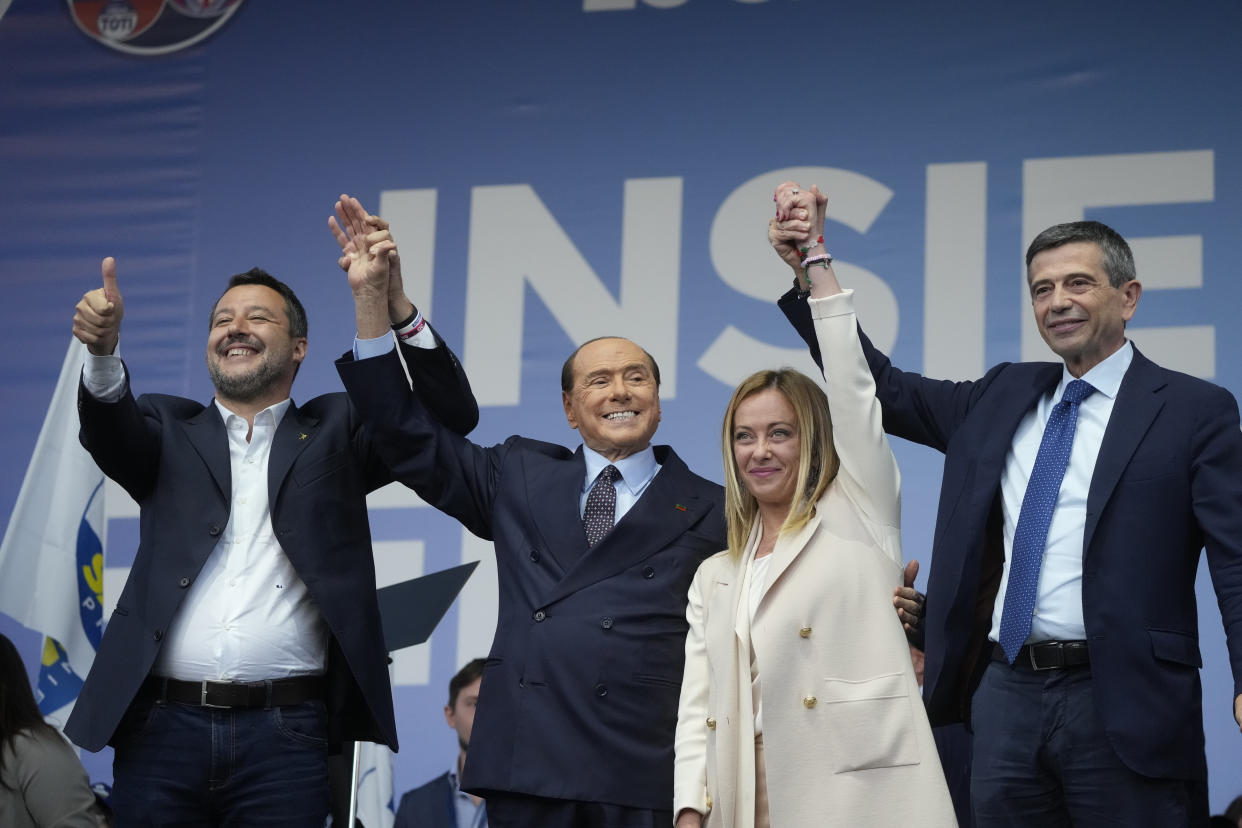 Matteo Salvini, Silvio Berlusconi, Giorgia Meloni and Maurizio Lupi stand together with held hands raised above their heads, smiling as if in victory.