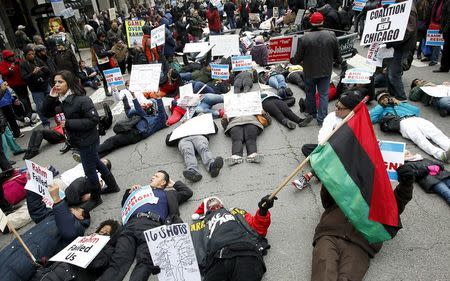 Protesters lie down on Chicago's Michigan Avenue in front of the Disney Store during a protest march against police violence in Chicago, Illinois December 24, 2015. REUTERS/Frank Polich