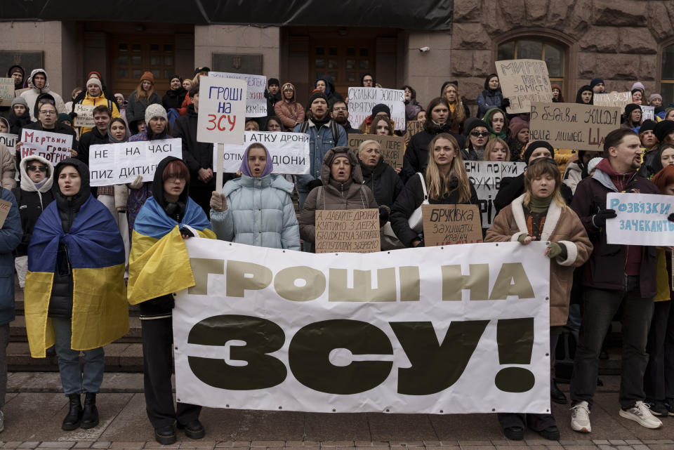 Ukrainians hold banners that read 'Money to the AFU', or Armed Forces of Ukraine, while attending a demonstration in central Kyiv, Ukraine, Saturday, Nov. 18, 2023. People gathered to protest against corruption and demand the reallocation of public funds to the Armed Forces. (AP Photo/Alex Babenko)