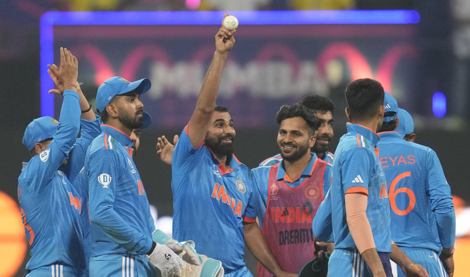 India's Mohammed Shami, center hold the ball as he celebrates his five-wicket haul after dismissing Sri Lanka's Kasun Rajitha during the ICC Men's Cricket World Cup match between India and Sri Lanka in Mumbai, India, Thursday, Nov. 2, 2023. (AP Photo/Rafiq Maqbool)