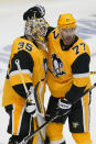 Pittsburgh Penguins goaltender Tristan Jarry (35) celebrates with Jeff Carter after the Penguins' 2-1 win over the New York Islanders in Game 2 of an NHL hockey Stanley Cup first-round playoff series in Pittsburgh, Tuesday, May 18, 2021. (AP Photo/Gene J. Puskar)