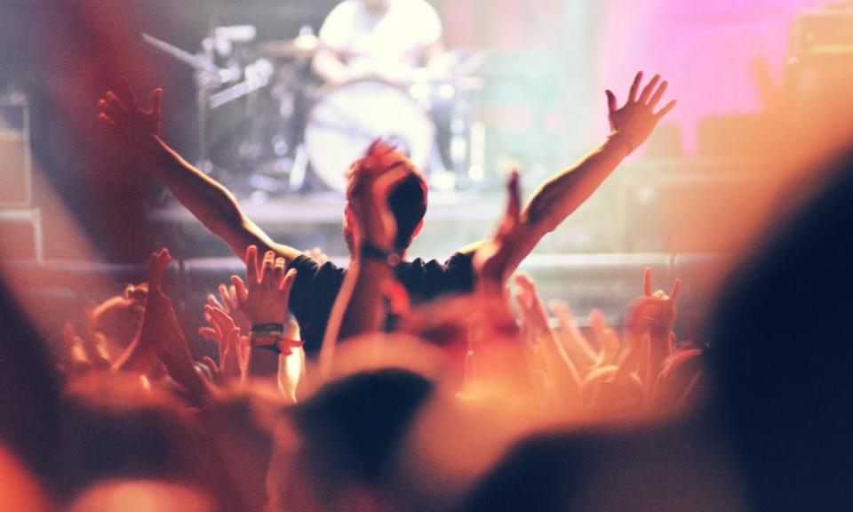 Silhouette of hands on a concert in front of bright stage lights