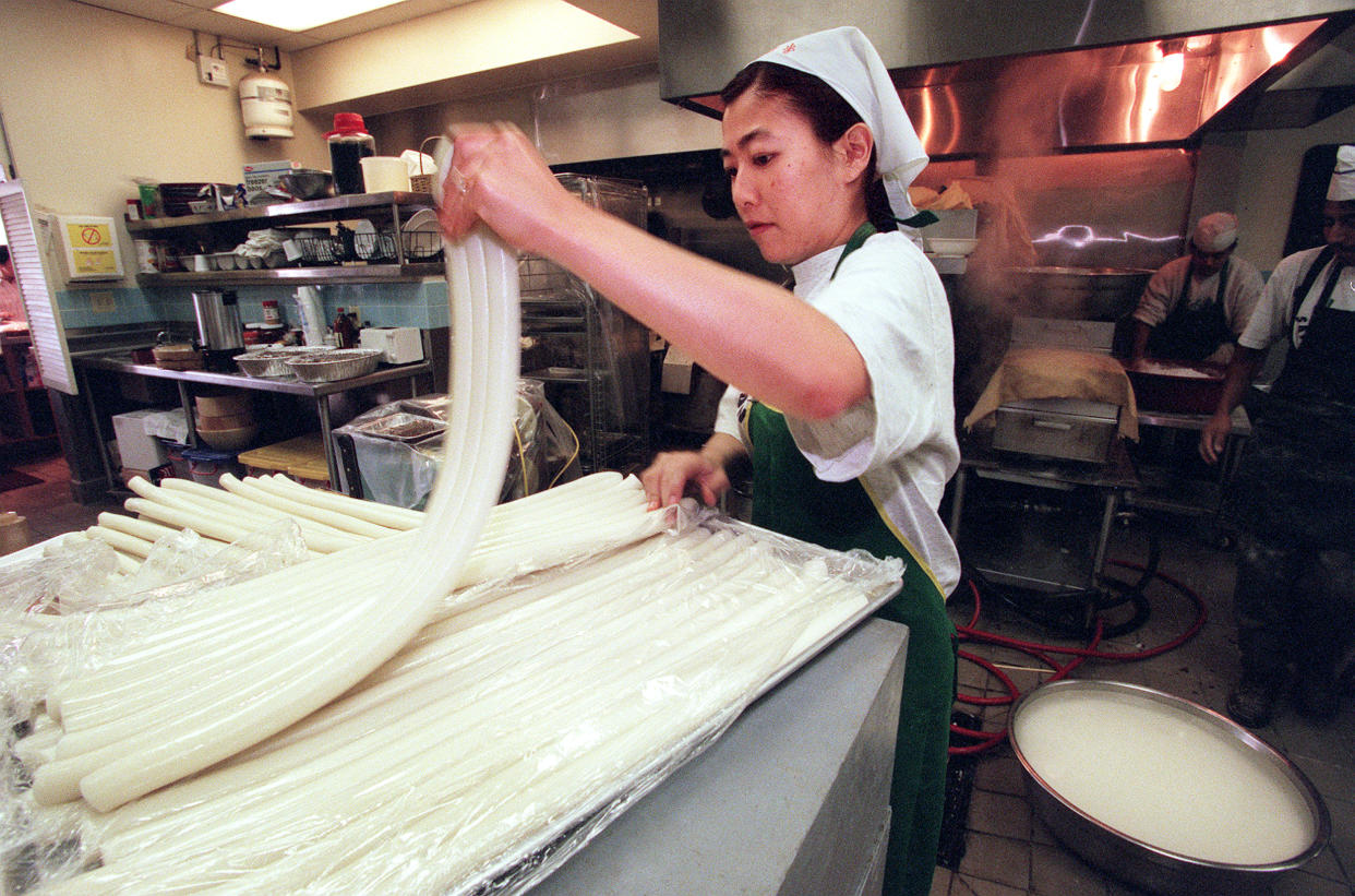 Yumi Yang pulls tteokbokki rice cakes apart before they are chopped up at San Su Jang rice cake shop in Los Angeles (Gina Ferazzi / Los Angeles Times via Getty Images file )