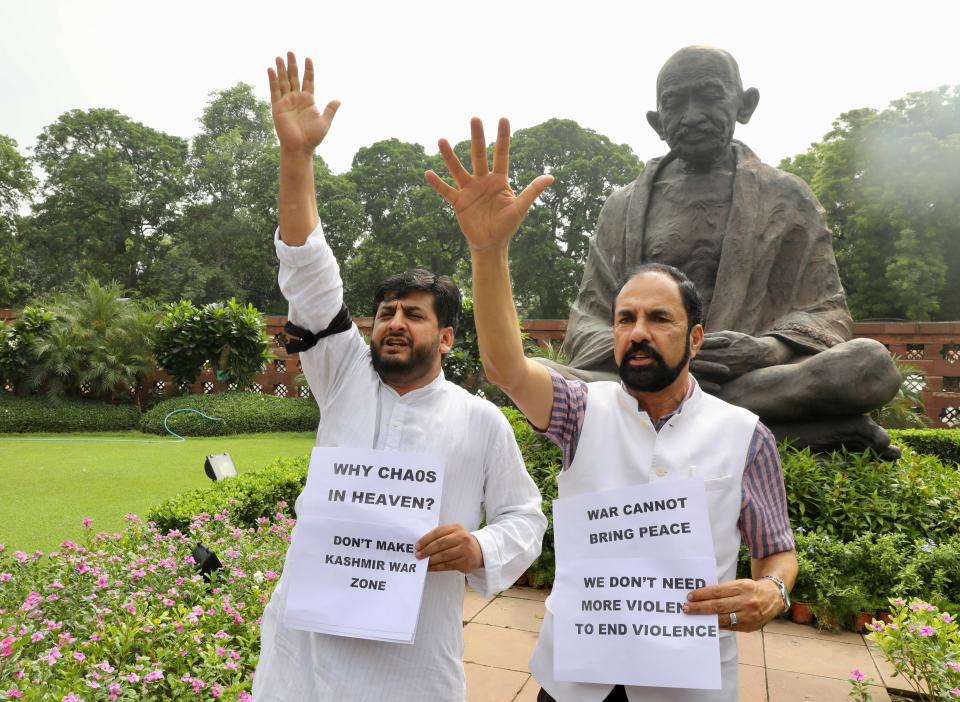 Opposition lawmakers hold placards against the Indian government's proposal to revoke disputed Kashmir's special constitutional status as they protest at the Parliament premises in New Delhi, India, Monday, Aug.5, 2019. India's government has proposed revoking disputed Kashmir's special constitutional status amid an uproar in Parliament. (AP Photo/Manish Swarup)