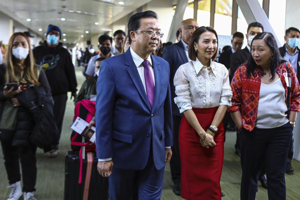 Chinese Ambassador to the Philippines Huang Xilian, left, and Philippine Department of Tourism Secretary Cristina Frasco, right, welcome the Chinese nationals arriving at the Ninoy Aquino International Airport in Manila on Tuesday, Jan. 24, 2023. (AP Photo/Gerard V. Carreon)