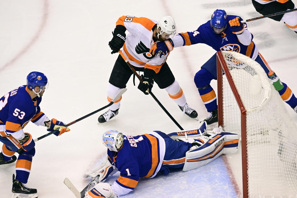 Philadelphia Flyers center Kevin Hayes (13) looks for a loose puck as New York Islanders center Casey Cizikas (53), defenseman Scott Mayfield (24) and New York Islanders goaltender Thomas Greiss (1) defend during the first period of an NHL hockey second-round playoff series, Sunday, Aug. 30, 2020, in Toronto. (Frank Gunn/The Canadian Press via AP)