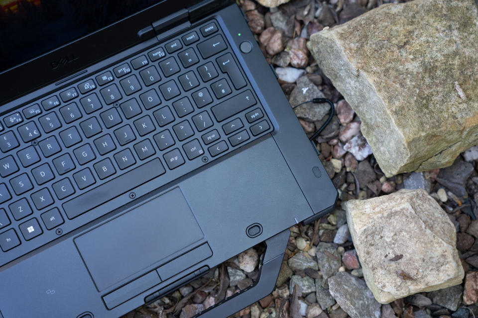 A black Dell Latitude 7330 Rugged Extreme laptop sitting on a rocky surface