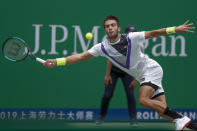 Borna Coric of Croatia reaches for the ball as he plays against Andrey Rublev, of Russia in their men's singles match at the Shanghai Masters tennis tournament at Qizhong Forest Sports City Tennis Center in Shanghai, China Tuesday, Oct. 8, 2019. (AP Photo/Andy Wong)