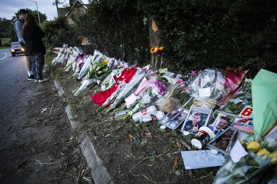People pay their respects at a memorial for four men who died in a car accident on the A4. (SWNS)