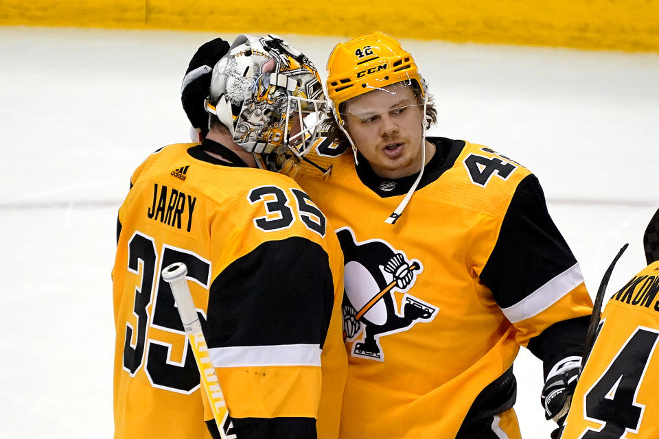 Pittsburgh Penguins' Kasperi Kapanen (42) celebrates with goaltender Tristan Jarry after the team's 5-1 win over the New Jersey Devils in an NHL hockey game in Pittsburgh, April 22, 2021. (AP Photo/Gene J. Puskar)