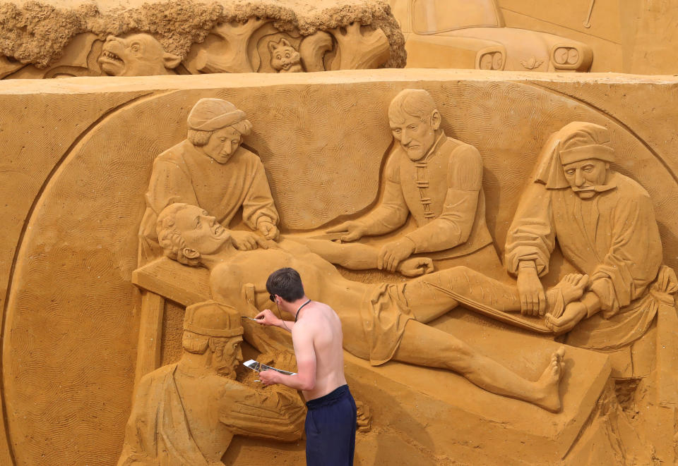 A sand carver works on a sculpture during the Sand Sculpture Festival "Dreams" in Ostend, Belgium June 18, 2019. (Photo: Yves Herman/Reuters)