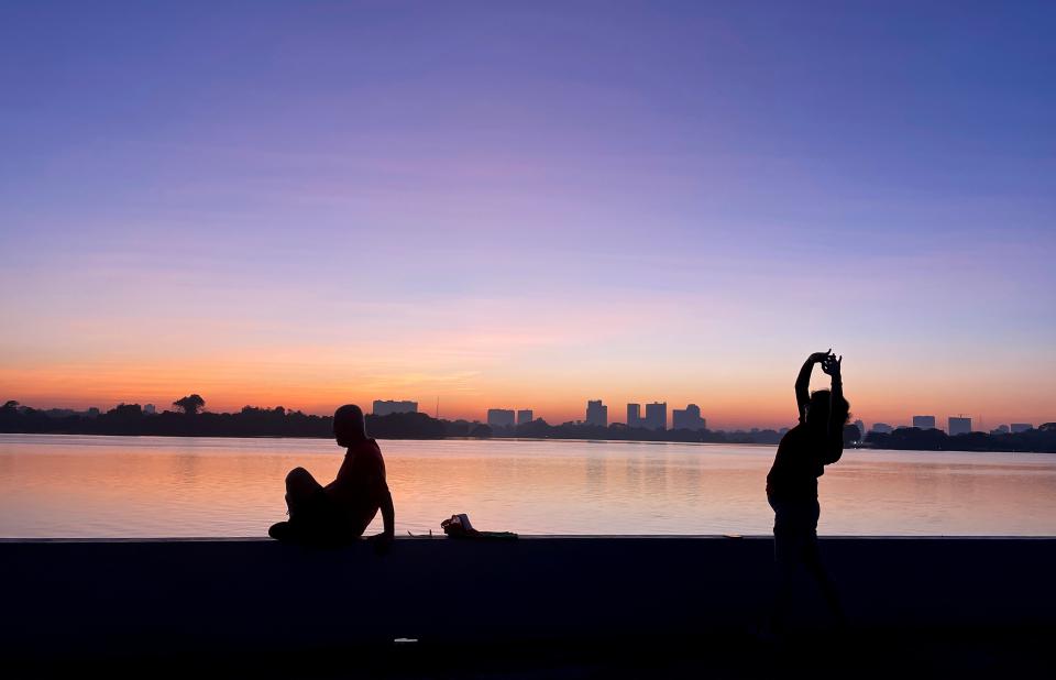 People workout on the bank of Inya lake at dawn on New Years Day in Yangon, Myanmar, 01 January 2024 (EPA)
