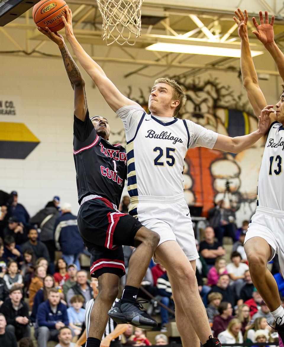 Fairdale's Brandon Smith blocks a shot by Taylor County's CJ Johnson (1). Fairdale defeated Taylor County, 70-67, on Tuesday night.