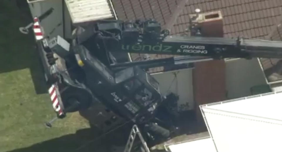 The crane crashed through the home's roof (pictured)