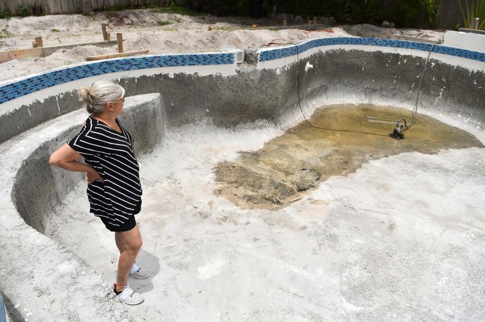 Debra Neger of Hobe Sound looks at her unfinished pool in 2021. She was one of a several homeowners across Florida accusing Amore Pools of stalling on pool construction.