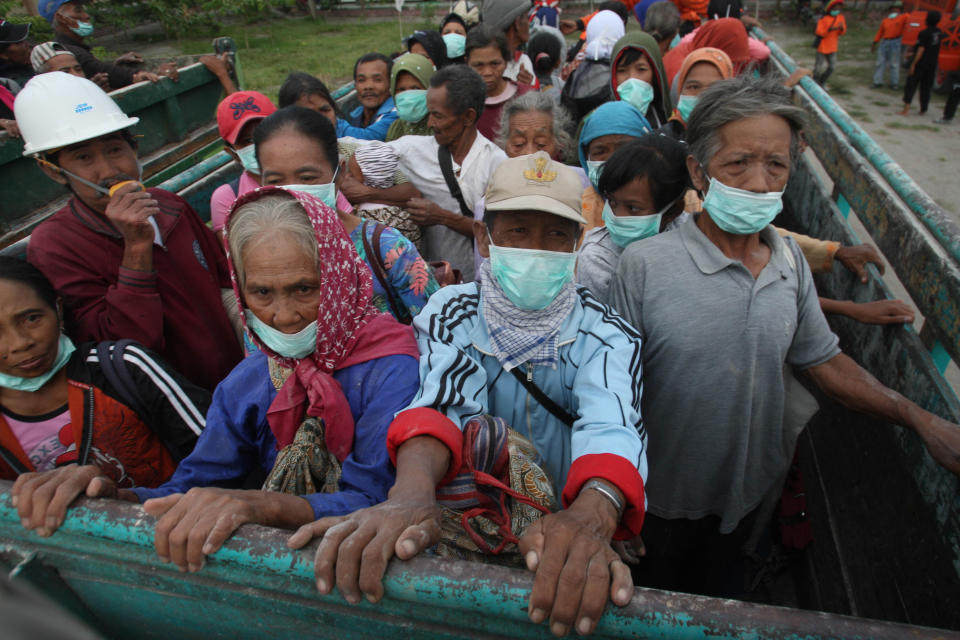 Villagers evacuate from their homes on the slope of Mount Kelud which erupted in Blitar, Indonesia, Friday, Feb 14, 2014. An explosive volcanic eruption on Indonesia's most populous island blasted ash and debris 18 kilometers (12 miles) into the air Friday, killing two people while forcing authorities to evacuate more than 100,000 and close six airports. (AP Photo/Trisnadi)