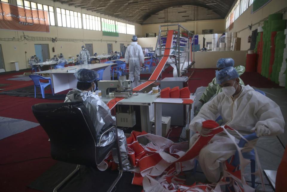 FILE- In this June 3, 2020 file photo, workers make protective face masks to be used to help curb the spread of the coronavirus at a factory in Kabul, Afghanistan. The confirmed death toll from the coronavirus has gone over 50,000 in the Middle East as the pandemic continues. That's according to a count Thursday, Sept. 3, 2020, from The Associated Press, based on official numbers offered by health authorities across the region. (AP Photo/Rahmat Gul, File)