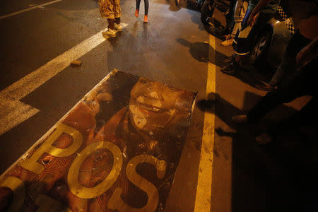 Demonstrators stand by a vandalized sign with an image of Nicaraguan Vice President Rosario Murillo during a protest against police violence and the government of President Daniel Ortega in Managua, Nicaragua April 23, 2018. REUTERS/Jorge Cabrera